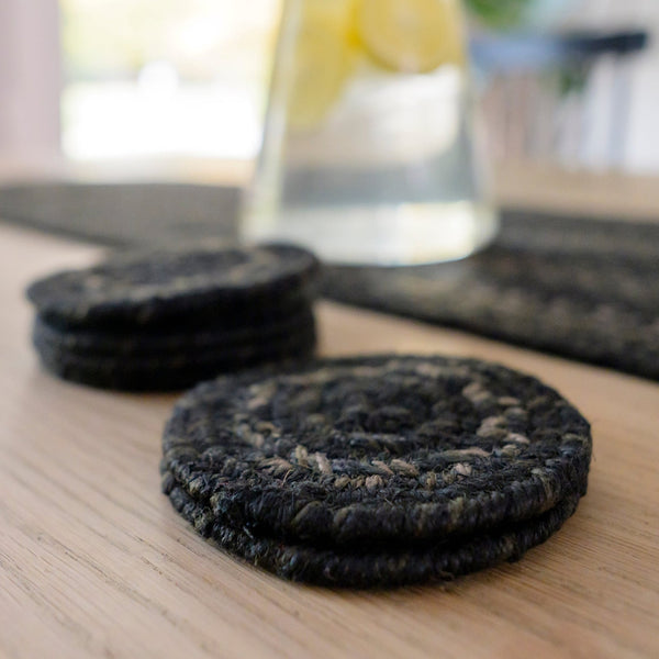 Set of six Jet Black braided jute coasters featuring black, charcoal, brown and tan tones in a handcrafted braided design