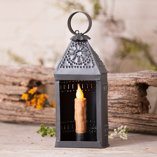 The Small Ship Lantern blends traditional country and colonial charm with modern farmhouse style, adding character to any decor. Crafted from durable metal with a Smokey Black finish, it's designed for use with a battery-operated taper (not included). Imported.