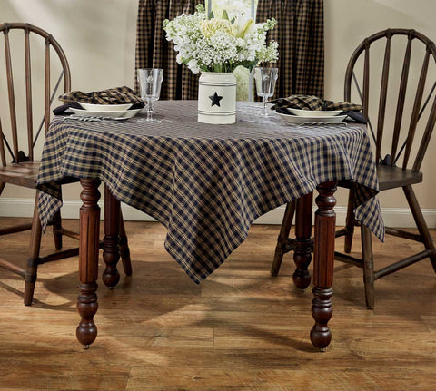 The Sturbridge Black Tablecloth offers a pretty, simple homespun plaid of farmhouse tan & black. The perfect table covering for everyday use or for setting a more formal table, this versatile table cloth fits your country home decor needs perfectly! 