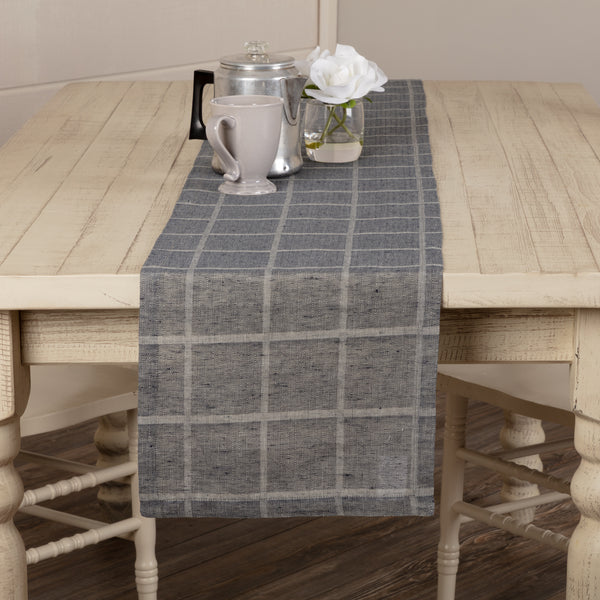 Effortlessly dress up your farmhouse table with our Julie Navy Plaid Runner 13x72. This classic table runner features a repeating windowpane woven grid, simply hemmed for a clean, finished look. Whether you're decorating the table for a special occasion or having a casual family dinner, the Julie Plaid Runner offers the perfect contemporary farmhouse feel for your kitchen.
