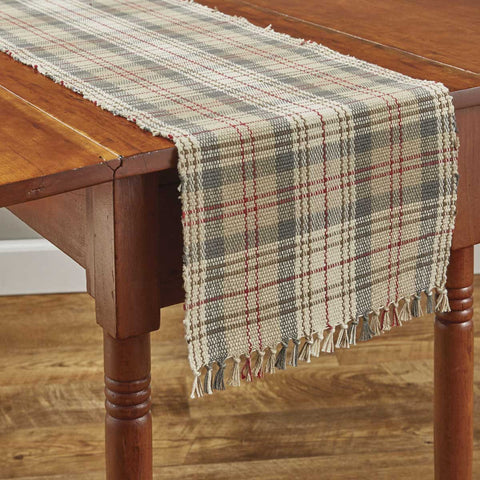 Neutral earthtone colors with a hint of deep red combine to make the handsome plaid in the Gentry Table Runners . Use alone or pair it with the matching placemats and napkins for the complete table setting!  Colors: Sand, Tan, Walnut Gray & Barn Red