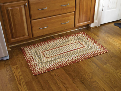 The Mill Village Braided Rug 27"x45 feature a vibrant garnet, combines it with green and cream, then softens it with buttercream to make these lovely rugs!