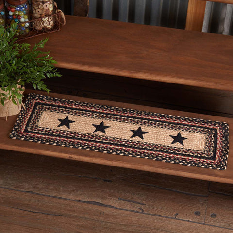 Colonial Star Jute Stair Tread Rect Latex 8.5x27, woven braided jute wool blend fabrics in natural, country black, and bright red displayed in concentric circles surrounding a prominent Colonial Star applique. Visit website for FREE s/h & discount offers. Primitive Country Farmhouse Home Decor.