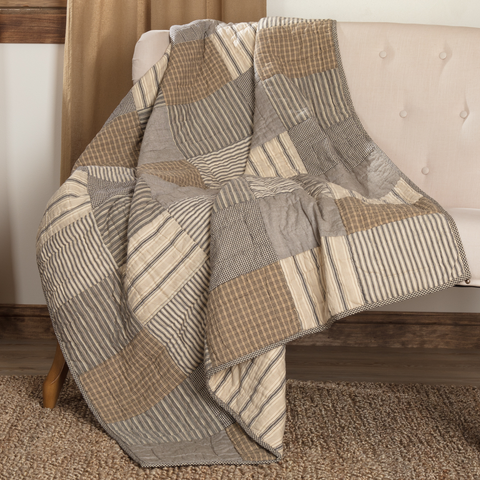 Bring farmhouse style to your home with the Sawyer Mill Charcoal Quilted Throw 60x50. Hand-quilted in charcoal, khaki, and cream cotton fabrics, this reversible throw adds rustic comfort and timeless charm to any space.