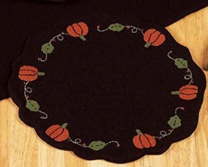 Pumpkins & Vines Black Candle Mat features applique pumpkins with green vines on a black background, finished with scallopped edges.