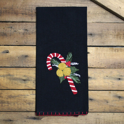 Candy Canes Black Towel has a black background with a single candy cane, nestled together with Holly and Jingle Bells.