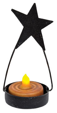 The Star Tealight Holder makes it easy to add a touch of light anywhere! Metal cup with a grainy black finish and a wire hanger, perfect for hanging from a hook, ribbon, or string, and topped with a folkart black tin star for a primitive accent. 4" H x 1-1/2" W, holds a single tealight candle. 