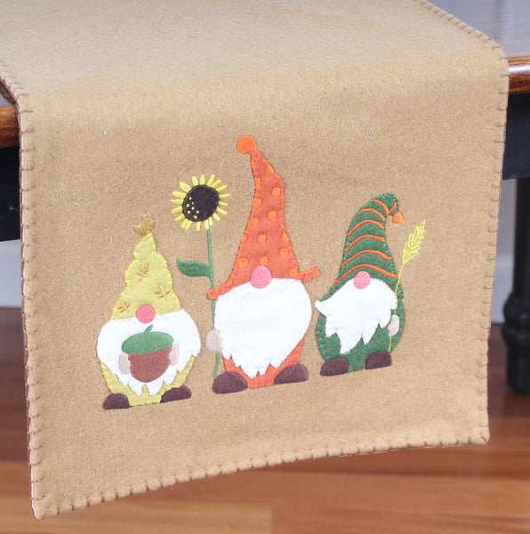 Fall gnome table runner features lovable gnome appliques on wool felt that create an adorable home accent to celebrate fall. 