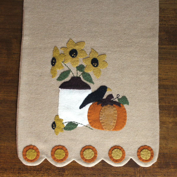 Nutmeg Fall Sampler Table Runnerfeatures applique details of a pumpkin, crown and flower vase. Perfect for your Fall Decor.