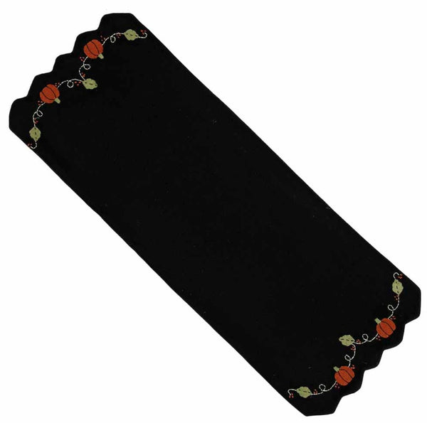 Pumpkins & Vines Black Table Runner features applique pumpkins with green vines on a black background, finished with scallopped edges.