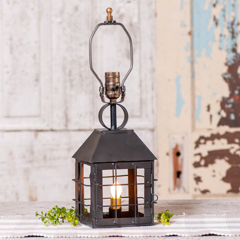 Take a step through time and peer into the romance of the past with this antiqued lamp crafted in the colonial style. This table lamp is wrought with a smokey black finish to give it an authentic rustic feel.