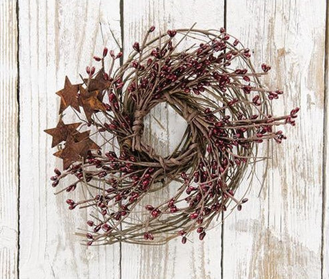 Burgundy Pip & Star Twig Wreath has dark branches and is accented with rusty metal stars. It has a 10" diameter.
