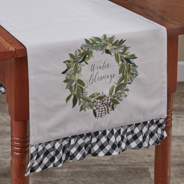 Bring the celebration and magic of the season to your table with the Winter Blessings Table Runner! A gorgeous festive wreath design surrounds the charming lettering and features a classic black and white plaid pattern accent on the end! Sure to charm your guests!